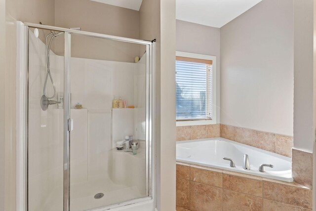 bathroom featuring a stall shower and a garden tub