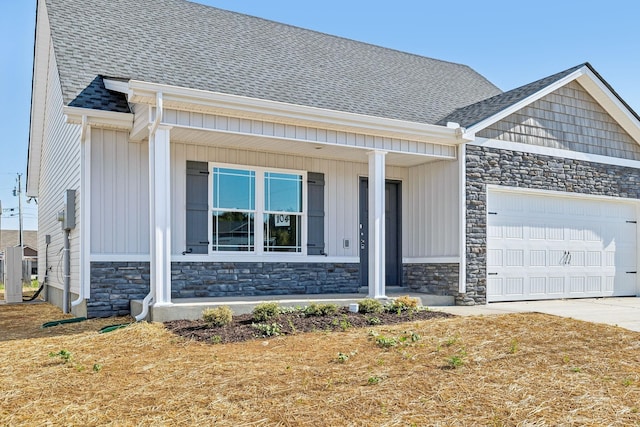 view of front of home featuring an attached garage, stone siding, a shingled roof, and driveway