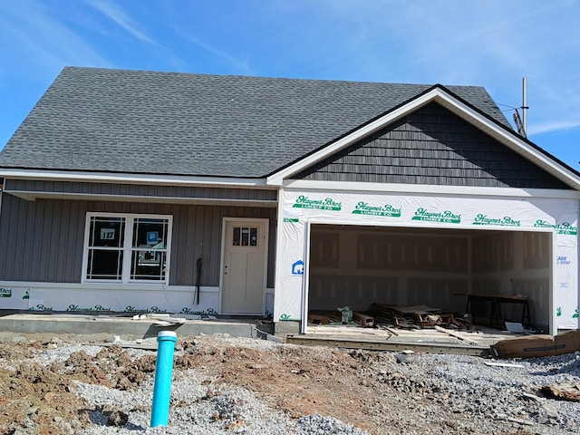 view of front of home with roof with shingles and an attached garage