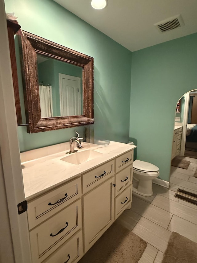 full bath with visible vents, vanity, and toilet