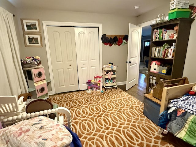 bedroom featuring baseboards, dark wood-type flooring, and a closet