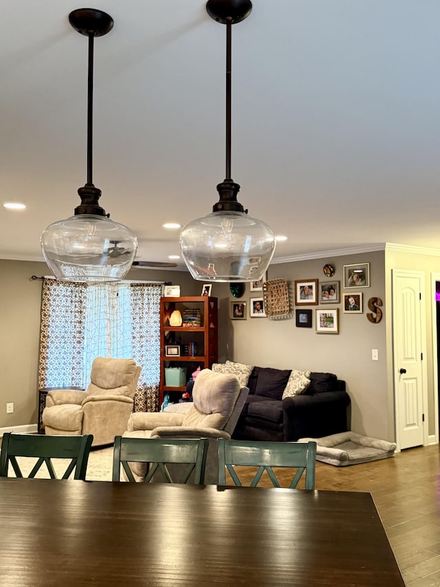 dining space with baseboards, ornamental molding, and wood finished floors