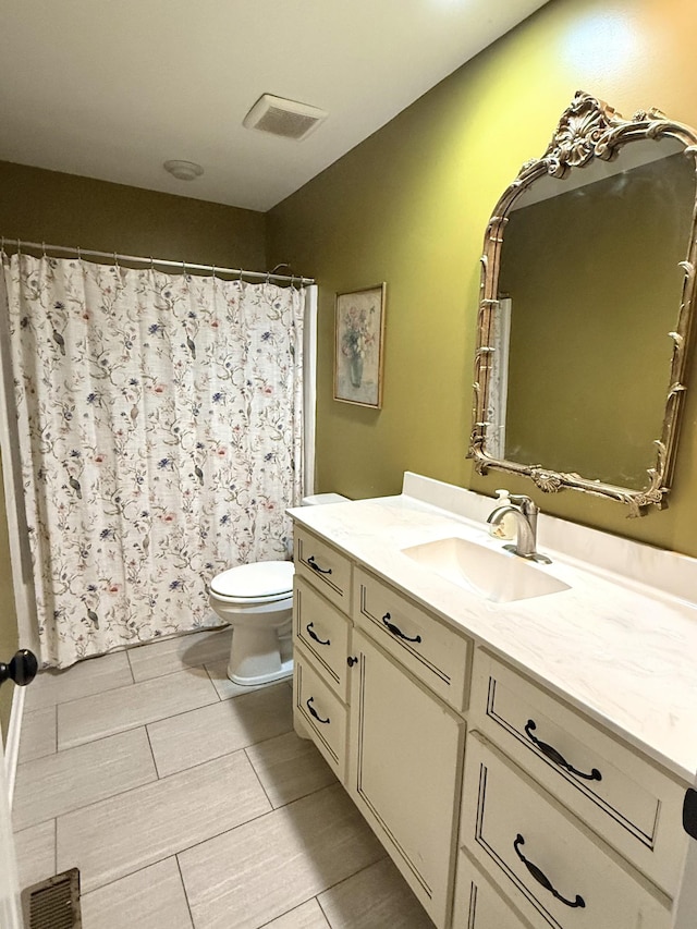 bathroom featuring visible vents, vanity, and toilet