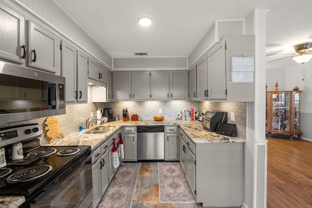 kitchen featuring stainless steel appliances, decorative backsplash, visible vents, and light stone countertops