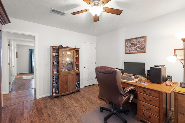 office space with baseboards, visible vents, ceiling fan, dark wood-type flooring, and a textured ceiling