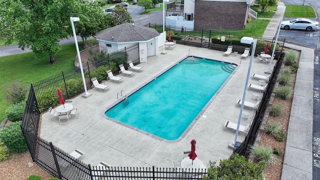 community pool with fence and a patio