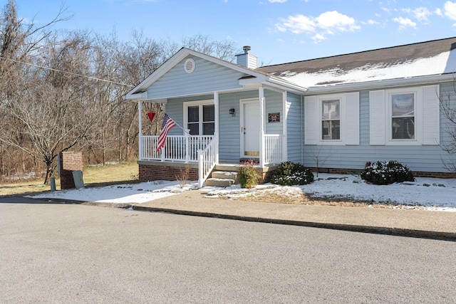 bungalow featuring covered porch and a chimney