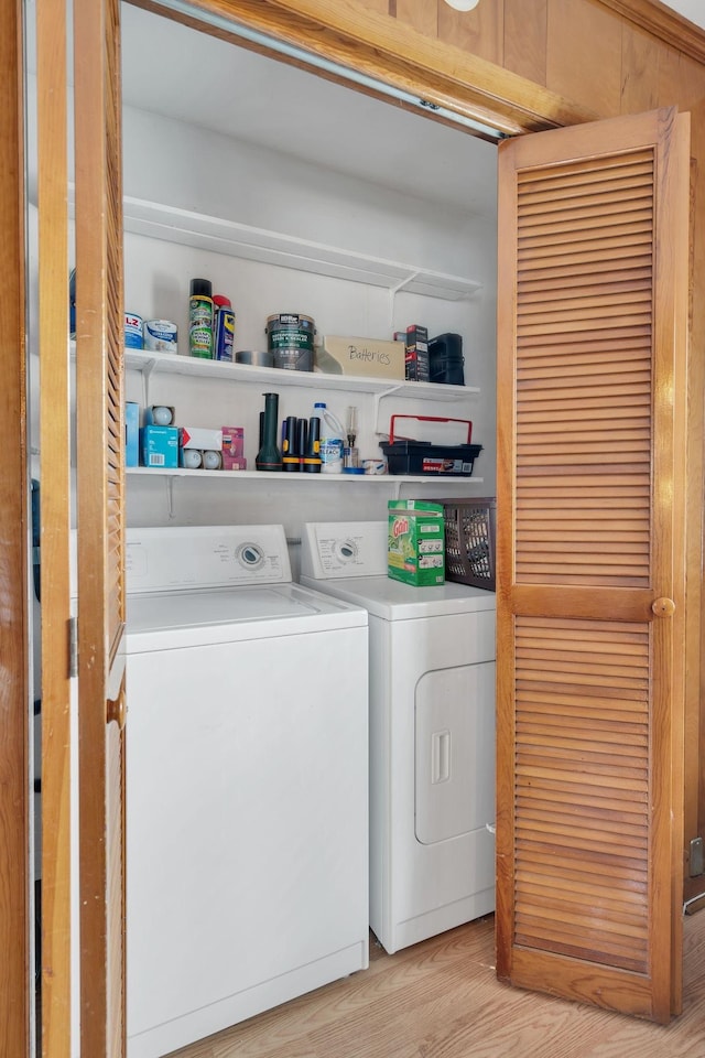 clothes washing area featuring light wood-type flooring, laundry area, and washing machine and clothes dryer