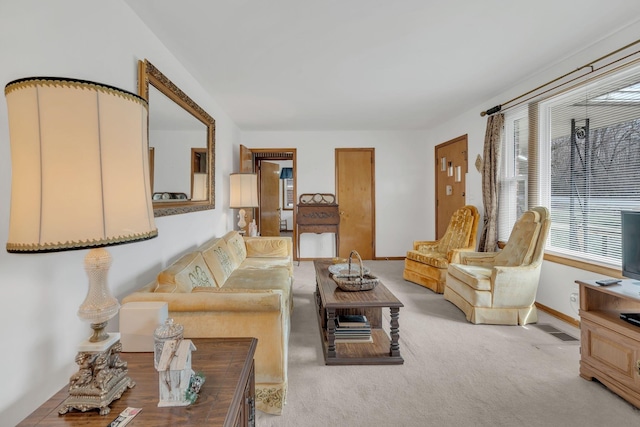 living area featuring light carpet, visible vents, and baseboards