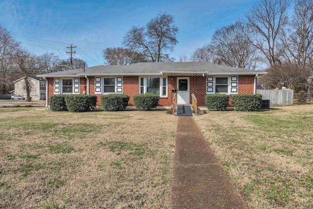 ranch-style house with entry steps, brick siding, fence, and a front lawn