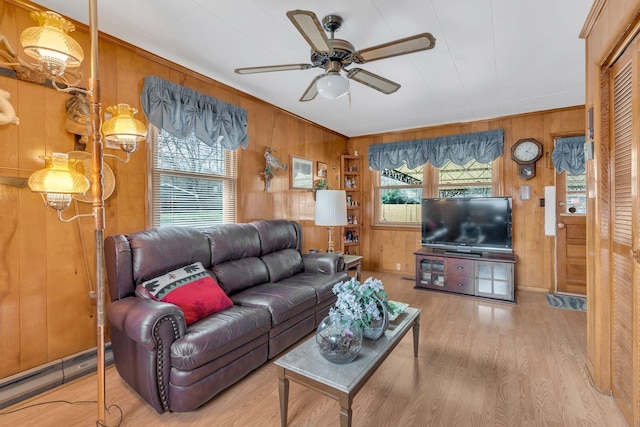 living room featuring wooden walls, a ceiling fan, and wood finished floors