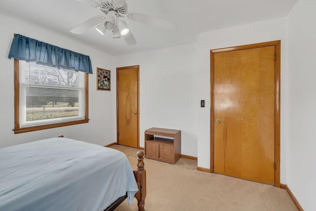 bedroom featuring light carpet, ceiling fan, and baseboards