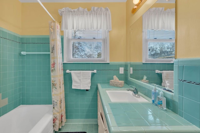 bathroom with tile walls, a wainscoted wall, vanity, and shower / bath combo