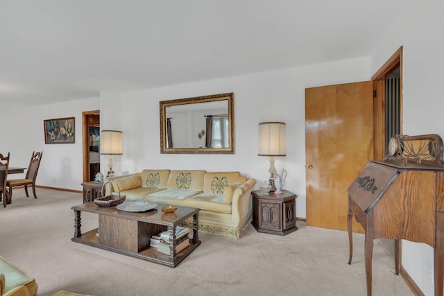 carpeted living area featuring baseboards