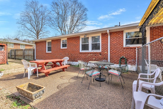 view of patio with an outdoor fire pit, outdoor dining area, and fence