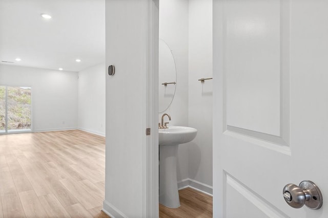 bathroom with recessed lighting, baseboards, and wood finished floors