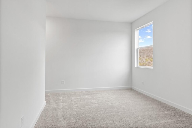 carpeted empty room featuring baseboards