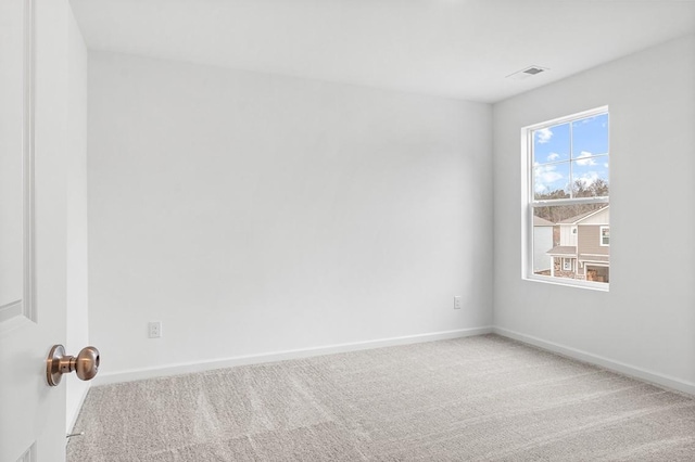 carpeted spare room featuring visible vents and baseboards