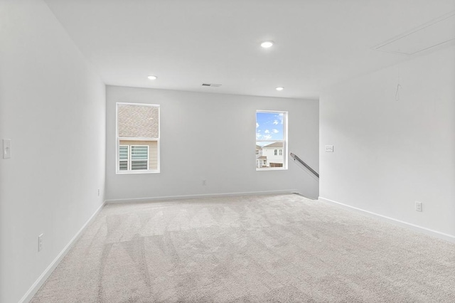 spare room featuring attic access, visible vents, baseboards, light colored carpet, and recessed lighting