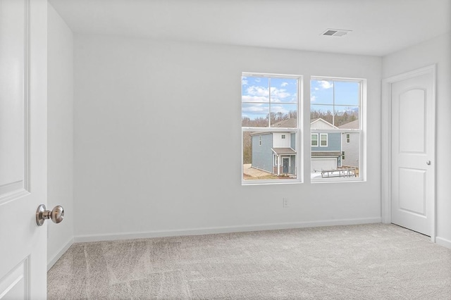 empty room with light carpet, visible vents, and baseboards