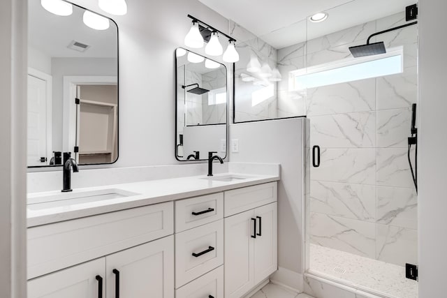 full bath with marble finish floor, visible vents, a sink, and a marble finish shower