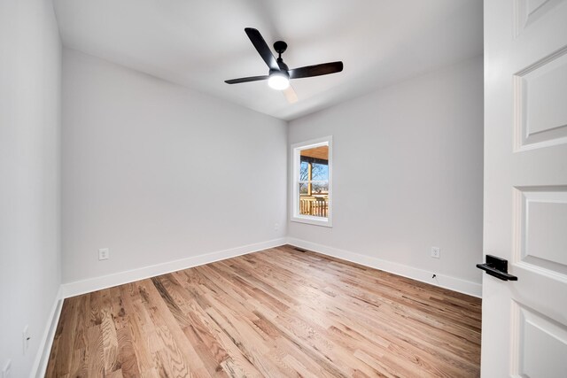 empty room with baseboards, ceiling fan, and light wood-style floors