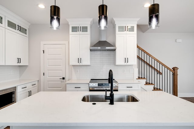 kitchen featuring white cabinets, tasteful backsplash, stainless steel appliances, and decorative light fixtures