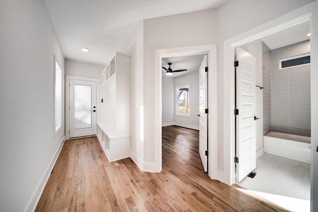 hall featuring light wood-type flooring, baseboards, and recessed lighting