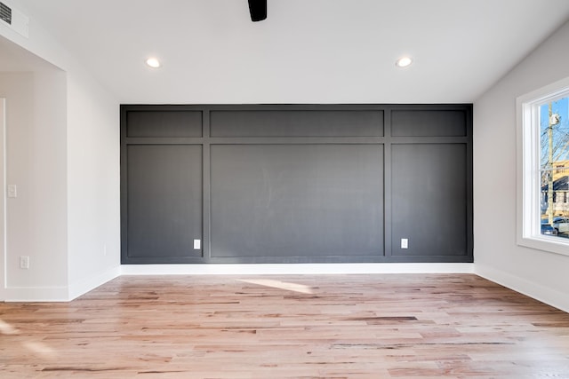 unfurnished bedroom with visible vents, recessed lighting, light wood-style flooring, and a decorative wall