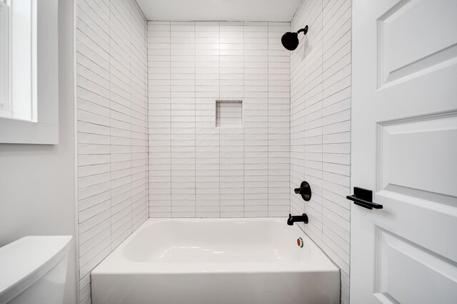 bathroom featuring shower / bathing tub combination and toilet