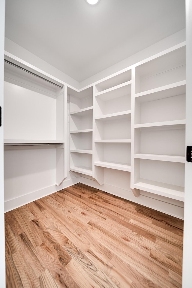 walk in closet with wood finished floors