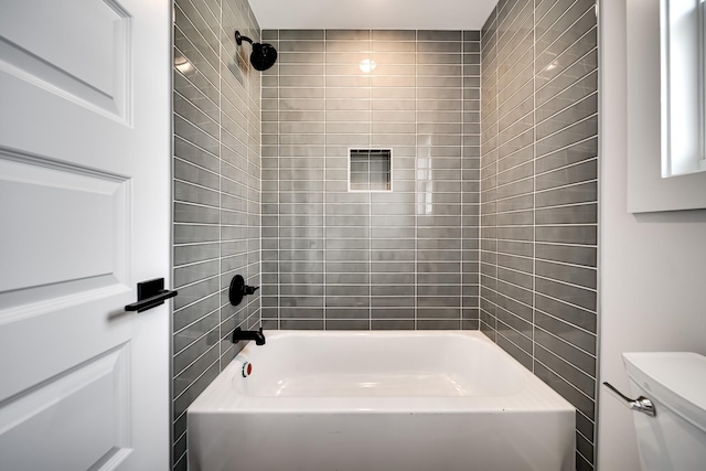 bathroom featuring washtub / shower combination and toilet