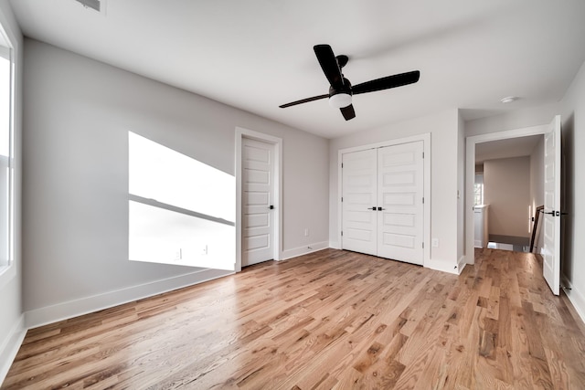 unfurnished bedroom with light wood-style flooring, baseboards, and a closet