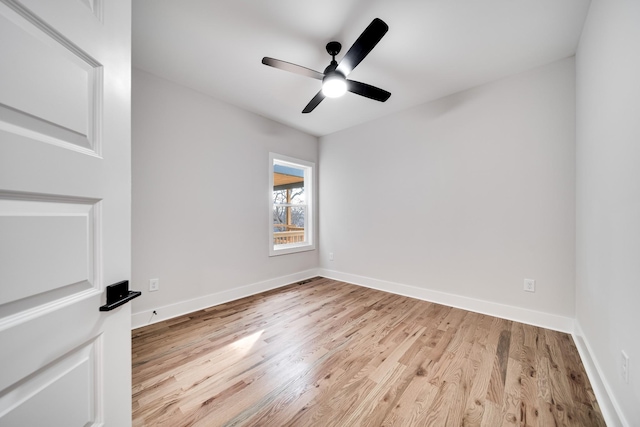 empty room featuring light wood-type flooring, baseboards, and a ceiling fan