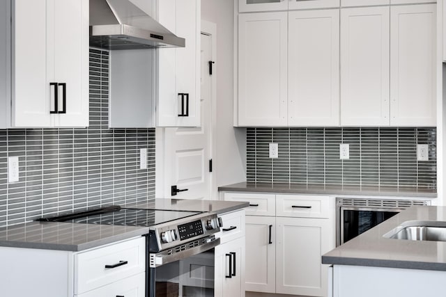 kitchen featuring range hood, electric stove, white cabinetry, and backsplash