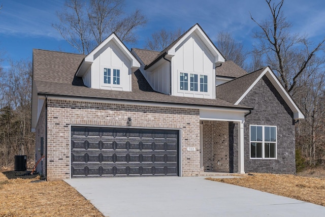 view of front of house with a shingled roof, concrete driveway, an attached garage, cooling unit, and brick siding