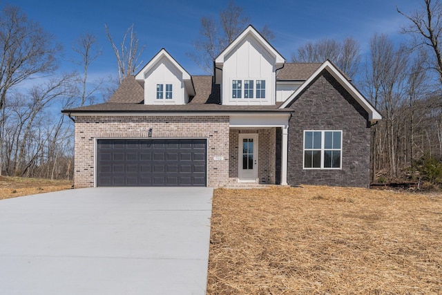 view of front of property with an attached garage, driveway, board and batten siding, and brick siding