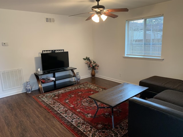 living area with visible vents, dark wood finished floors, and baseboards