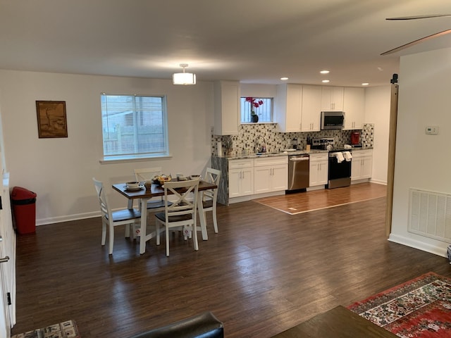 kitchen with stainless steel appliances, visible vents, white cabinetry, light countertops, and decorative light fixtures