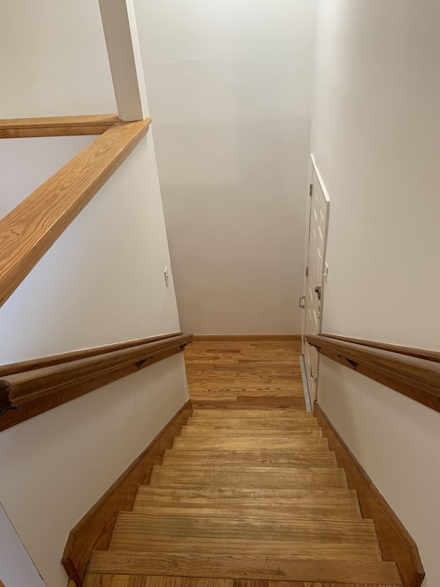 stairway featuring baseboards and wood finished floors