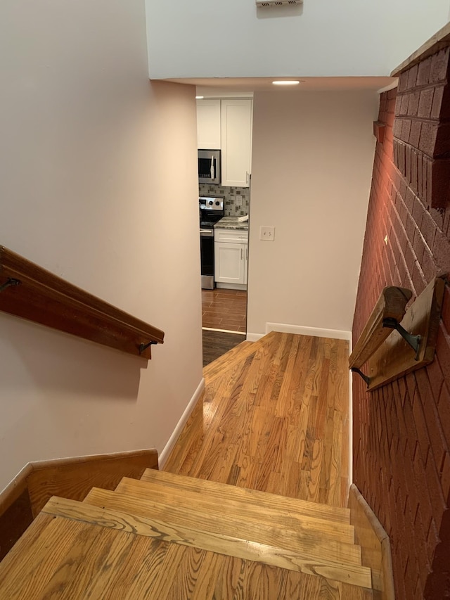 stairs featuring wood finished floors and baseboards