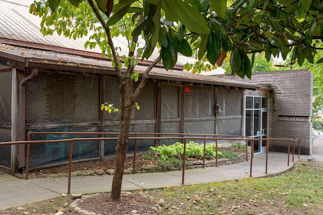 exterior space with a sunroom and brick siding