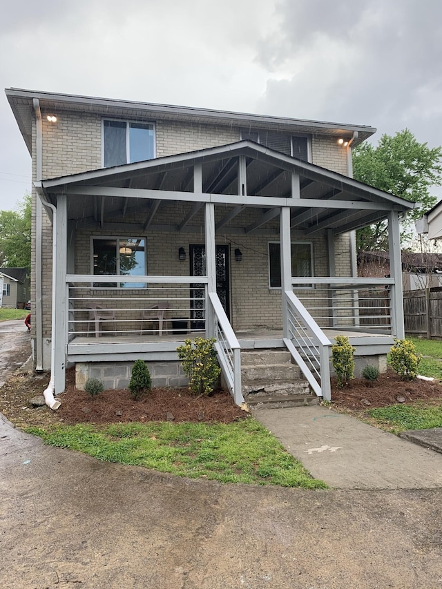 view of front of house with covered porch and brick siding