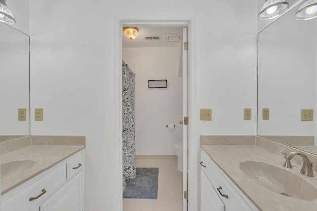 bathroom featuring two vanities, a sink, visible vents, and toilet