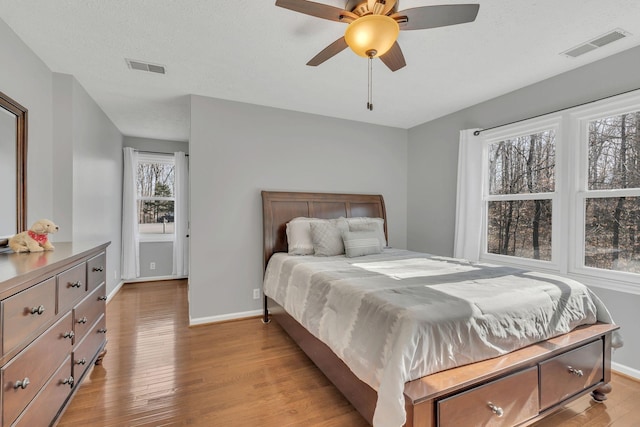 bedroom featuring baseboards, visible vents, and light wood-style floors