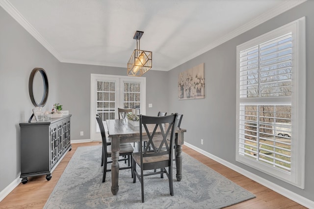 dining room with crown molding, baseboards, and wood finished floors