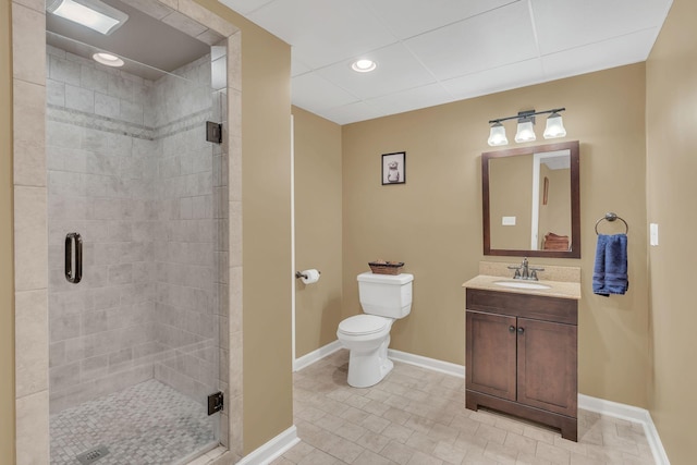 bathroom with toilet, a shower stall, vanity, and baseboards