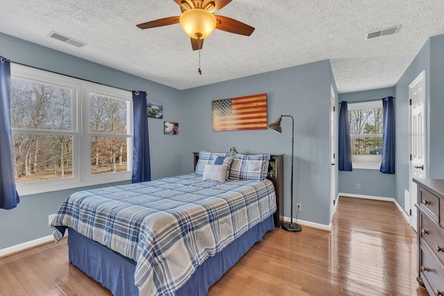 bedroom with light wood-type flooring, baseboards, and visible vents