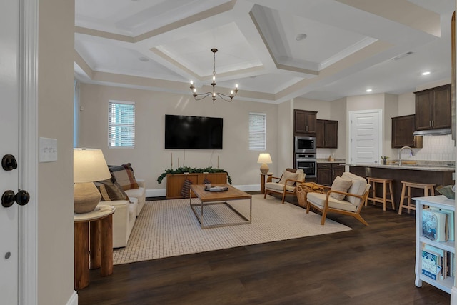 living room with dark wood finished floors, recessed lighting, an inviting chandelier, coffered ceiling, and baseboards