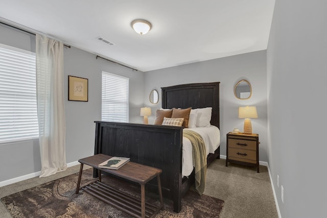 bedroom with baseboards, visible vents, and dark carpet